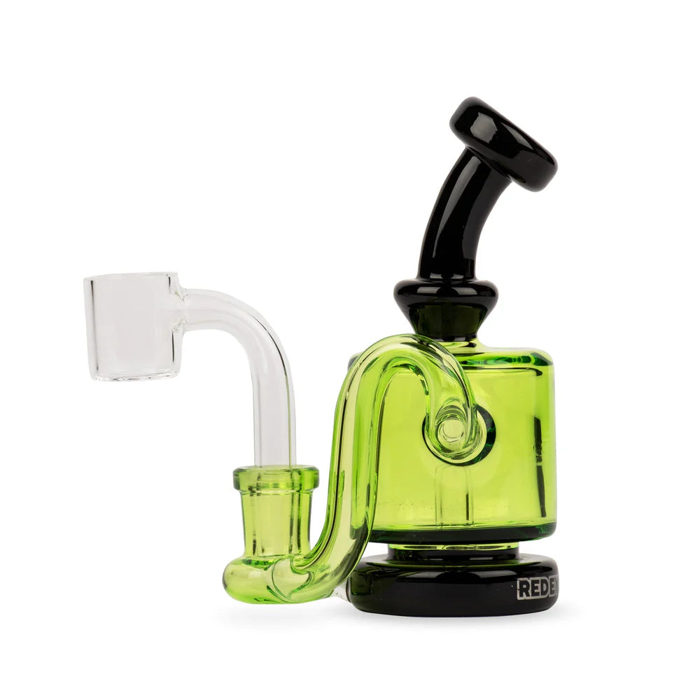 Glass smoking device with green body and black accents on a white background