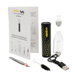 The image shows a dry herb vaporizer pen with a black body and a yellow and orange box with the HONEYstick brand on it. The vaporizer is designed for heating chamber with precision temperature settings.